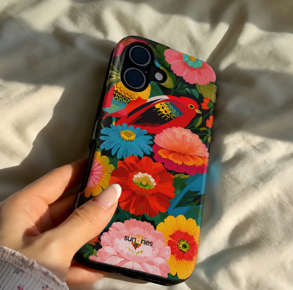 Colorful floral phone case held by a hand on a light fabric background