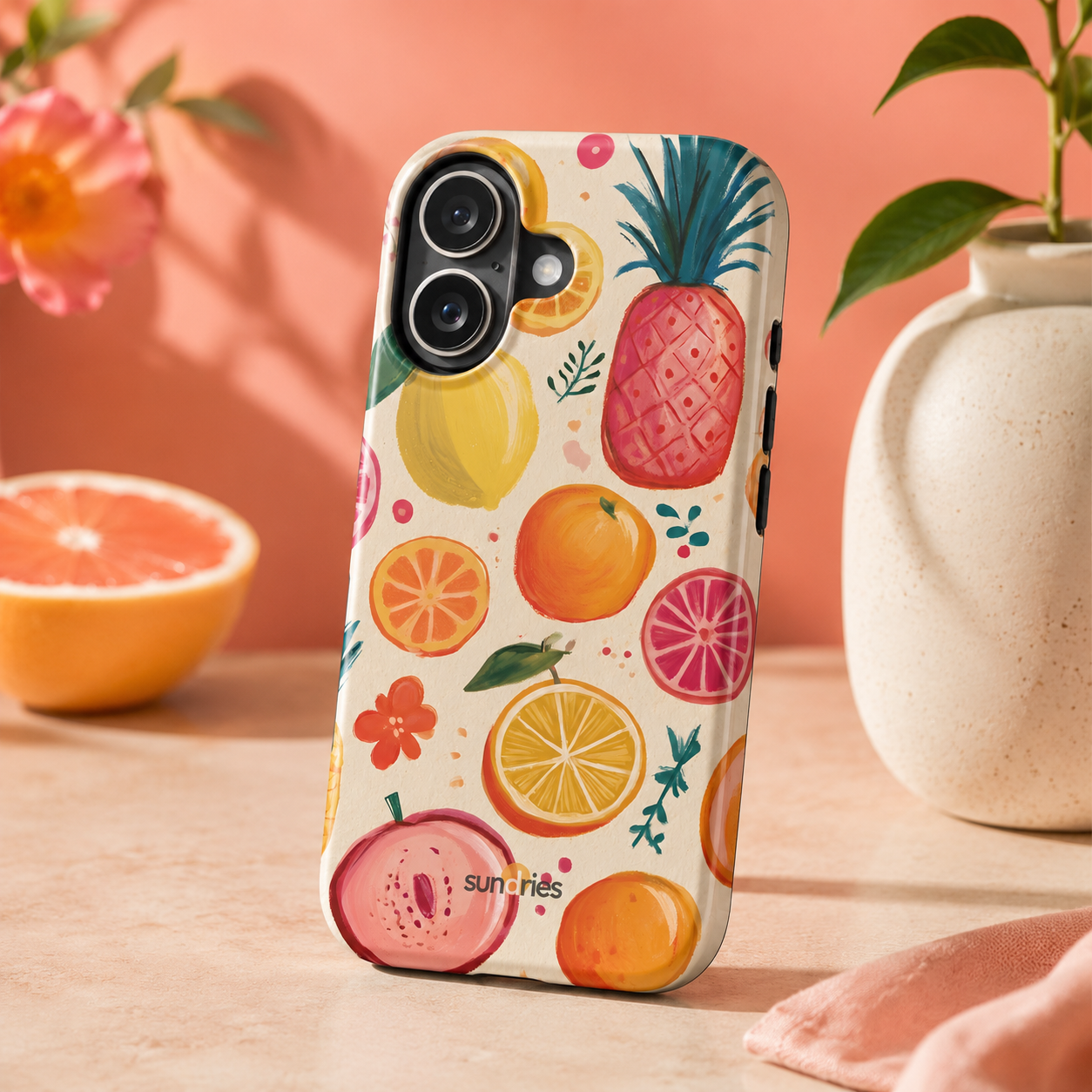 Phone case with fruit pattern on a wooden surface with a pink background