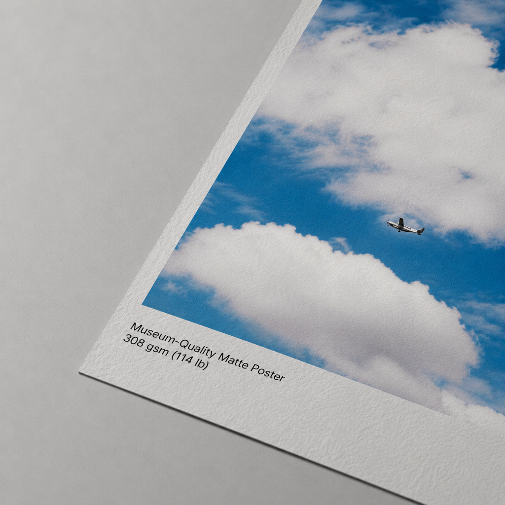 Museum-quality matte poster with an airplane flying through a blue sky with clouds.
